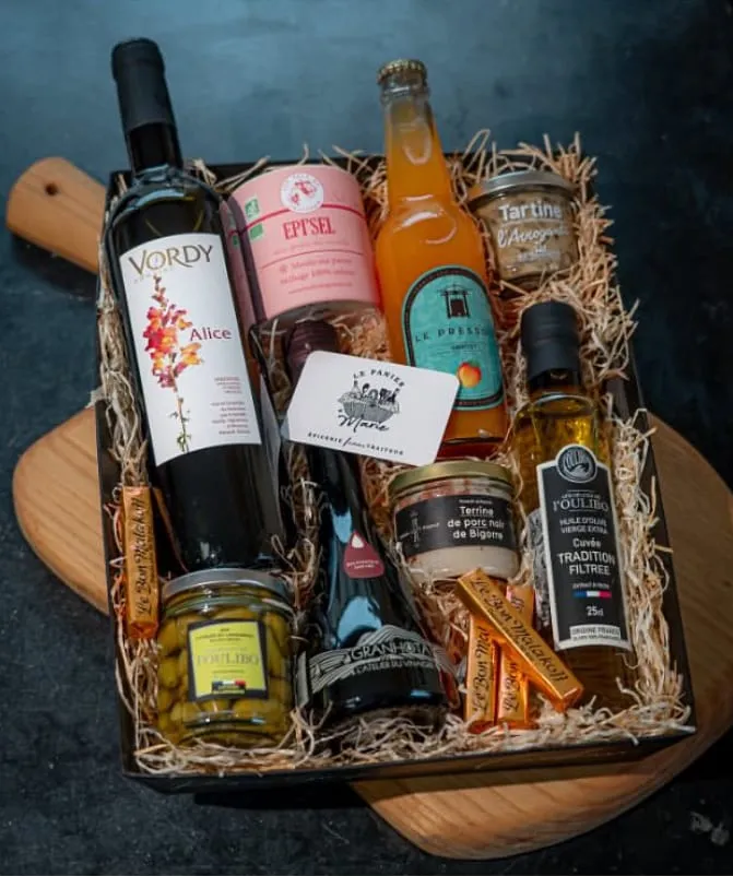 Coffret gourmand avec deux bouteilles de vin, de l’huile d’olive, des terrines et des olives