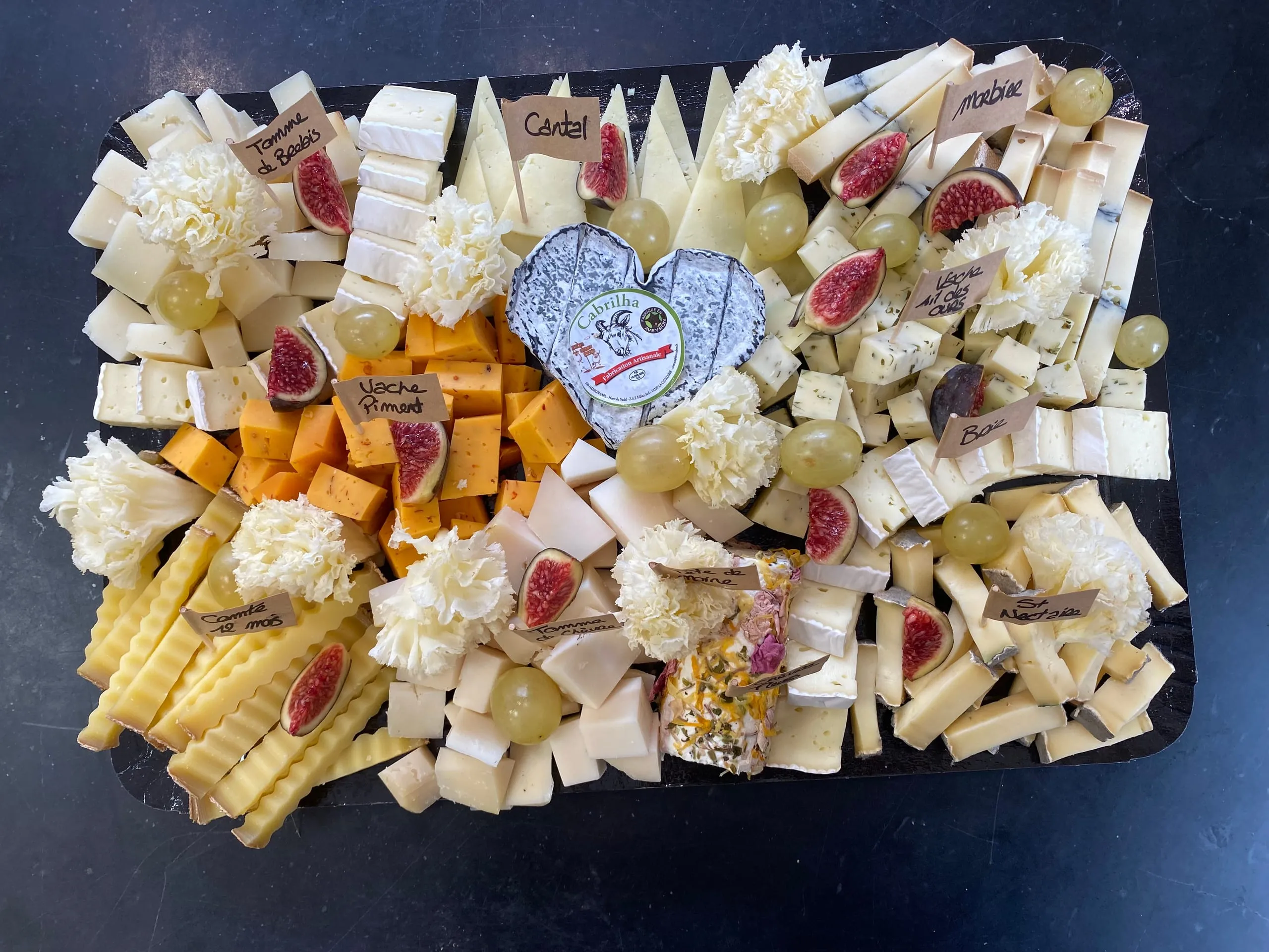 Plateau de fromages variés accompagné de figues et de raisins