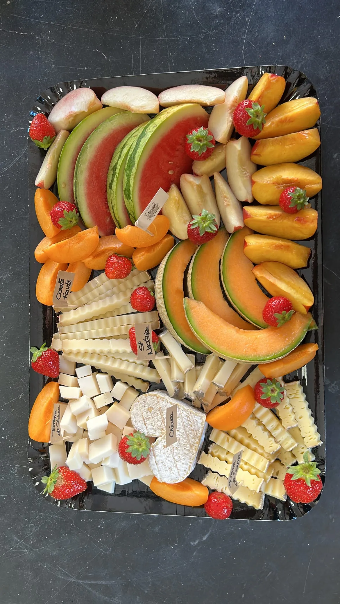 Plateau de fromages accompagné de melon, pastèque, pêches et fraises