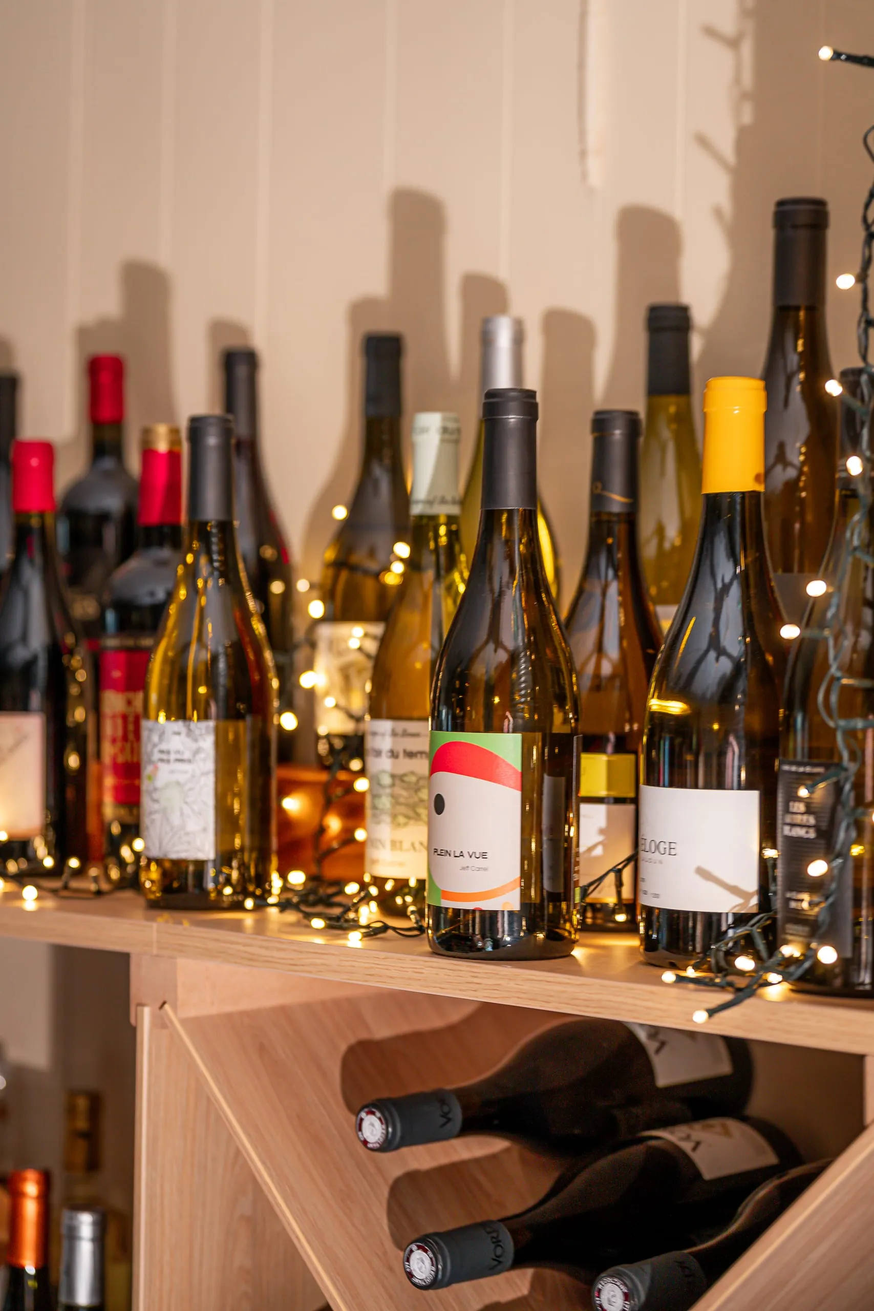 Bouteilles de vin exposées sur les étagères de la cave avec des lumières chaleureuses