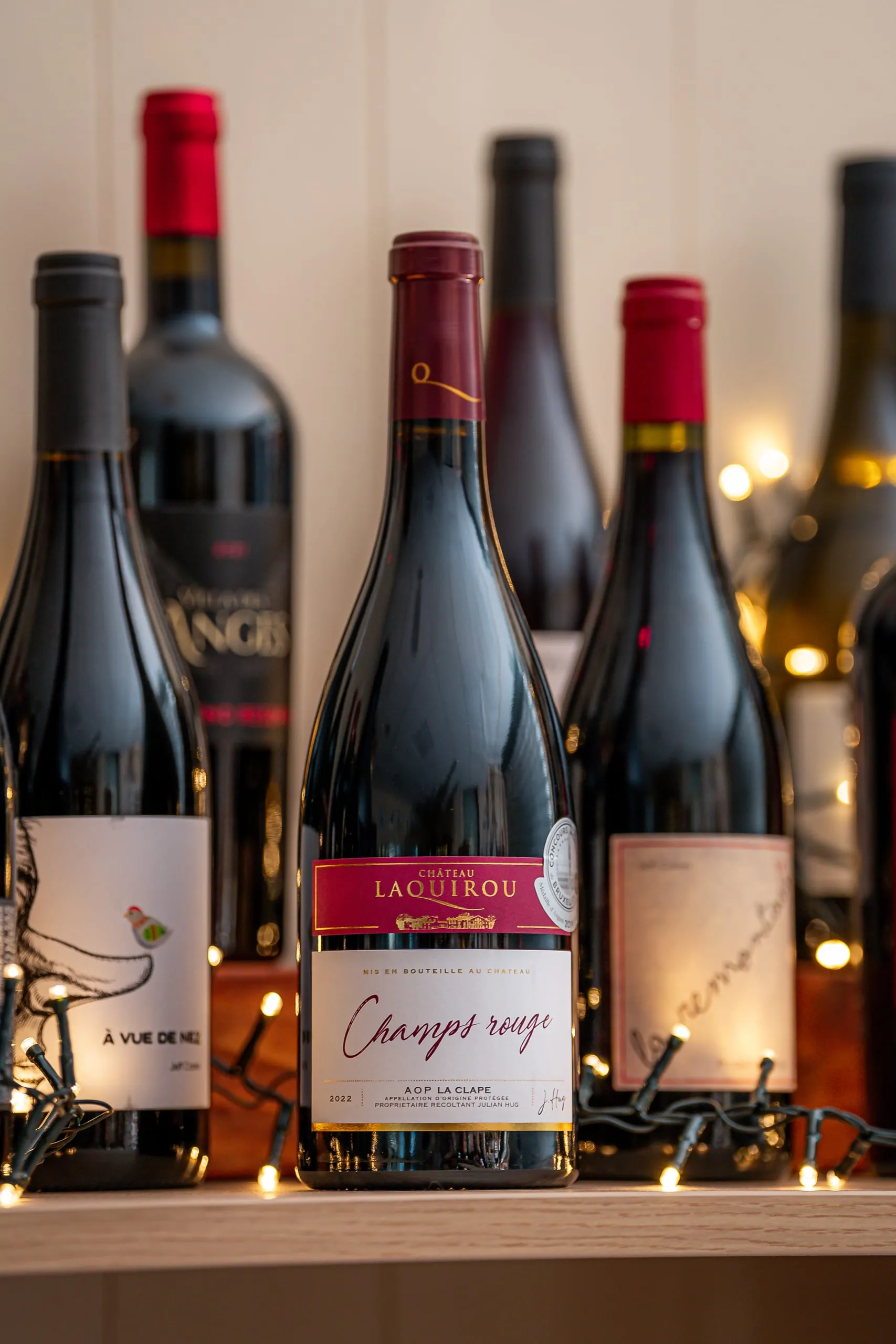 Bouteilles de vin rouge exposées dans la cave avec des lumières chaudes